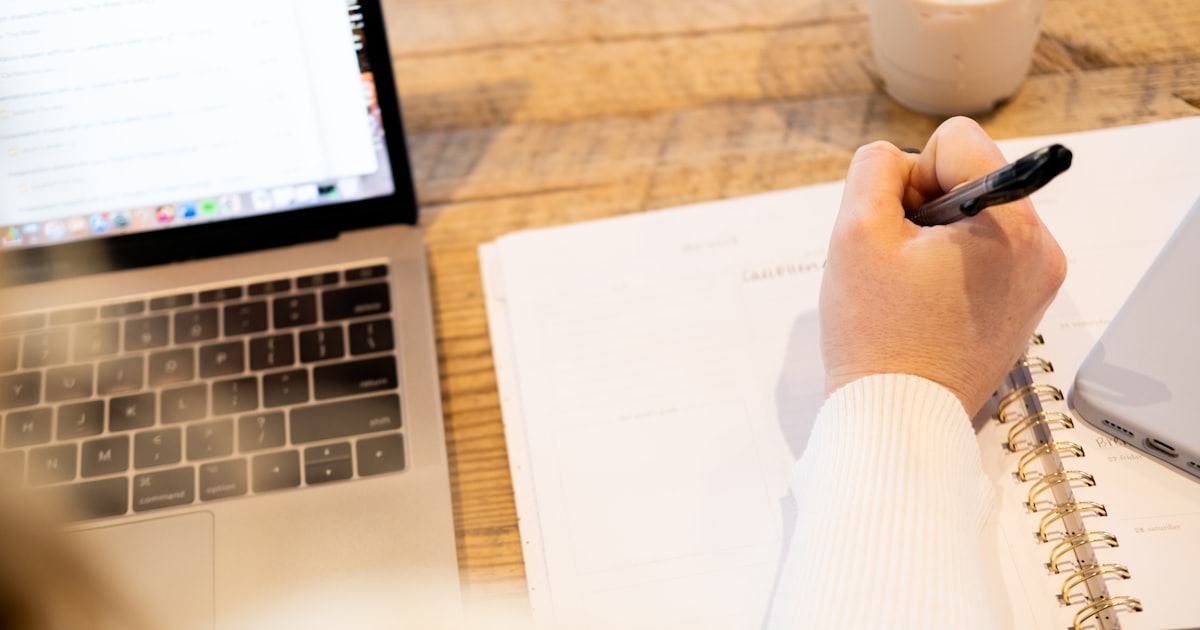 A freelance email copywriter drafting a client campaign on a laptop at a desk