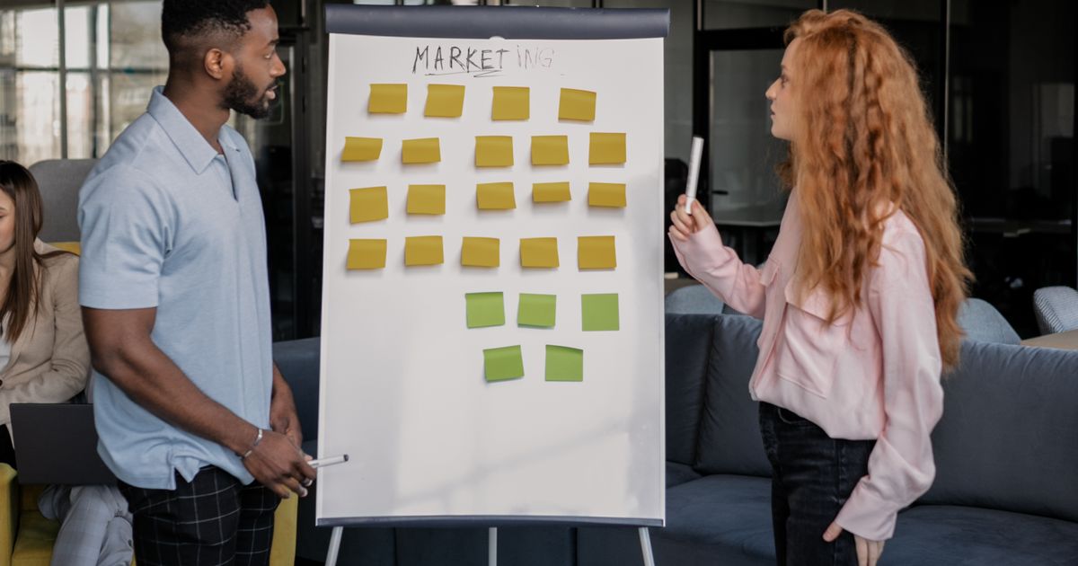 A marketing team mapping out an email campaign schedule on a whiteboard